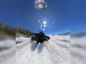 A thrilling moment on the water as a speedboat cuts through the waves under the bright sun, showcasing the excitement of boating adventures.