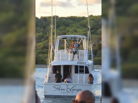 A lively group enjoys their time aboard the 'Paso Largo' yacht, showcasing a fun atmosphere perfect for celebrations and gatherings on the water.