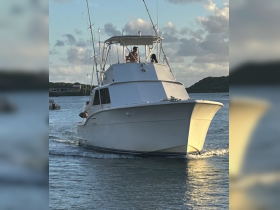 A boat navigates through calm waters with guests onboard, showcasing a perfect day for a boating adventure.