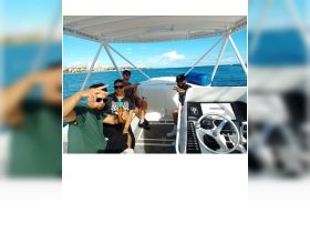 A lively group enjoys their time aboard a boat, celebrating with drinks and good vibes under the sun — perfect for a fun day on the water.