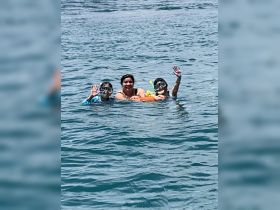 A joyful family enjoys snorkeling in clear waters, showcasing a fun-filled day of swimming and exploration together.