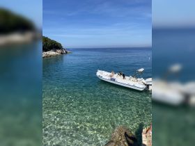A serene scene featuring a boat anchored in crystal-clear waters, with guests enjoying the sun and swimming nearby — a perfect getaway for relaxation and fun.