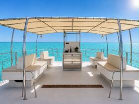 A spacious interior view of a boat featuring comfortable seating and a helm area, perfect for relaxing while enjoying the stunning turquoise waters.
