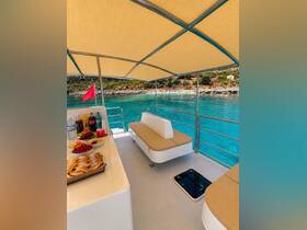 A cozy interior view of a boat's lounge area, featuring comfortable seating and a selection of refreshments, perfect for relaxing while enjoying the stunning turquoise waters.