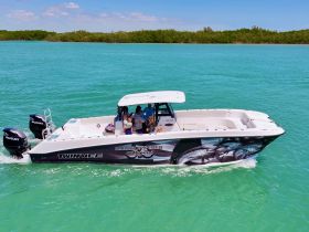 A family enjoys a day on the water aboard a Twin Vee charter boat, surrounded by stunning turquoise waters — perfect for creating unforgettable memories.