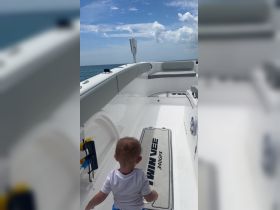 A young child explores the interior of a boat, showcasing the spacious seating area and inviting atmosphere — perfect for family outings on the water.