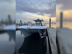 A sleek speedboat is docked at the marina, with guests visible in the background, showcasing a perfect setting for a day on the water.