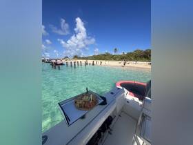 A beautifully arranged platter of snacks on the deck of a boat, perfect for enjoying while anchored near a serene beach. Ideal for catering on private charters.
