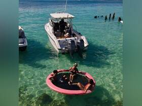A fun day on the water with friends enjoying a floating mat while anchored near a boat — perfect for summer adventures and relaxation in crystal-clear waters.