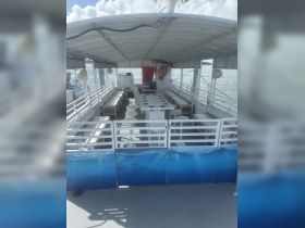 Interior view of a spacious boat cabin featuring ample seating and a helm area, perfect for group outings and charters.