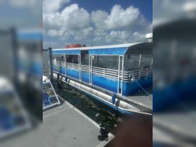A clear view of a pontoon boat docked at the marina, showcasing its spacious design and inviting atmosphere for group outings.
