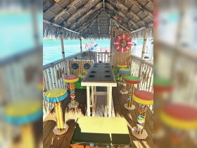 A vibrant interior view of a boat's lounge area featuring colorful seating and a bar, perfect for relaxing and enjoying the scenic waters.
