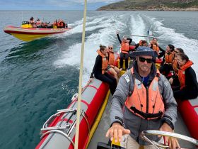 A lively group enjoys an exhilarating boat ride, showcasing the thrill of ocean adventures with friends.