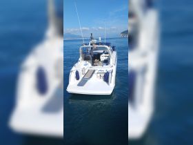 A sleek speedboat cruising through clear waters, showcasing its elegant design and inviting seating area — perfect for a day on the water.