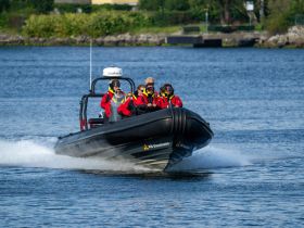 A group of excited passengers enjoys a thrilling ride on a speedboat, showcasing the fun of on-water adventures.