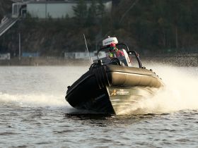 A speedboat cuts through the water, showcasing an exhilarating ride on the waves — perfect for adventure seekers and water sports enthusiasts.