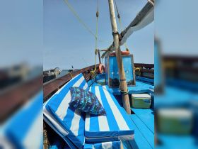 A cozy interior view of a boat featuring comfortable blue and white striped seating, perfect for relaxing while enjoying a day on the water.