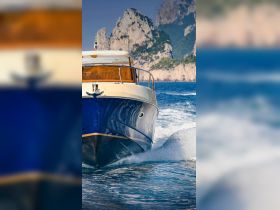 A stunning view of a yacht cutting through the waves, showcasing its sleek design against a backdrop of rocky cliffs — perfect for luxury boating experiences.