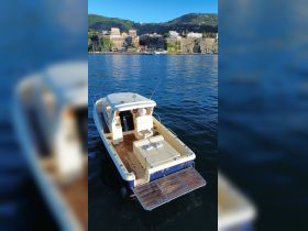 A well-appointed boat interior featuring a helm and comfortable seating, perfect for leisurely cruises on the water.