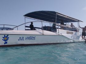 A lively scene aboard the 'Jul Hybris' boat with guests enjoying their time on the water, showcasing the perfect atmosphere for a fun day out.