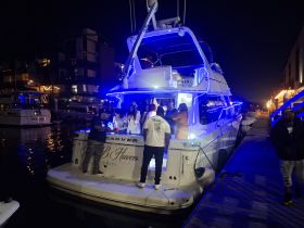 A lively group enjoys a night out on a beautifully lit boat, perfect for celebrations and gatherings on the water.