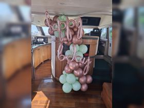 Colorful birthday decorations featuring balloons and a 'Happy Birthday' sign inside a boat, perfect for celebrating special occasions on the water.
