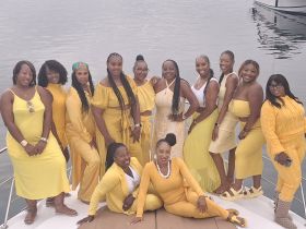 A vibrant group of friends dressed in yellow poses for a memorable photo on a yacht, capturing the essence of celebration and camaraderie on the water.