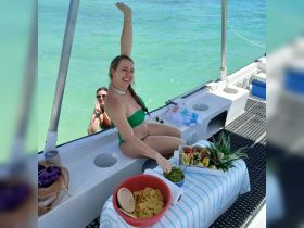 Guests enjoy a vibrant spread of snacks and fresh fruit aboard a boat, perfect for a fun day on the water.