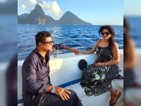 A couple enjoys a romantic moment on a boat with stunning ocean views and mountains in the background, perfect for memorable getaways.