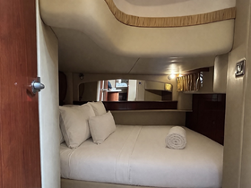 Cozy cabin interior of a boat featuring a comfortable bed with plush pillows and a neatly rolled towel, perfect for relaxing during a voyage.