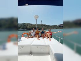 A group of friends enjoys a sunny day on a boat, posing for a fun photo with a scenic backdrop — perfect for memorable outings and celebrations on the water.