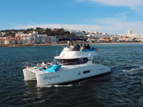 A lively group enjoys a day on a catamaran, cruising through scenic waters with a beautiful coastal backdrop — perfect for group outings and adventures.