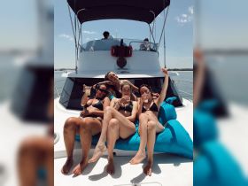 A lively group of friends enjoys cocktails on a yacht, celebrating together under the sun — perfect for summer parties and memorable outings on the water.