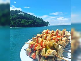 Delicious grilled chicken and vegetable skewers served on a plate, perfect for enjoying a meal while cruising on the water. Ideal for catering on boat trips.