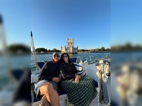 A couple enjoys a toast on their boat with a stunning landmark in the background, perfect for romantic outings and memorable celebrations on the water.