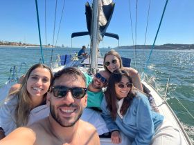 A joyful group of friends enjoys a sunny day sailing, capturing smiles and camaraderie on the water — perfect for memorable outings and celebrations.