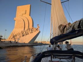 A scenic view of a sailing trip featuring a prominent monument, with guests enjoying the experience on the boat — perfect for sightseeing and exploring coastal landmarks.