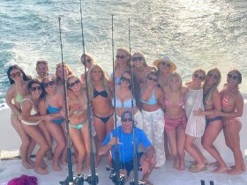 A lively group of friends celebrates aboard a fishing boat, perfect for bachelorette parties or group outings on the water.