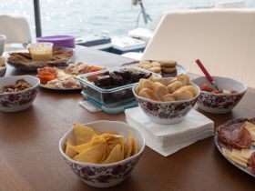 A beautifully arranged spread of snacks and charcuterie on a boat, perfect for enjoying while cruising on the water.