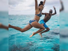 A joyful couple leaps into the vibrant turquoise waters, capturing the excitement of a fun day on the ocean — perfect for adventure seekers and beach lovers.