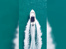 Aerial view of a sleek speedboat cutting through vibrant turquoise waters, showcasing the thrill of boating adventures.