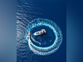An aerial view captures a yacht and speedboat creating dynamic wake patterns in the deep blue sea, showcasing the thrill of boating adventures.
