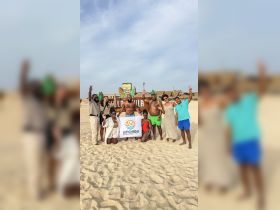 A joyful group poses on the beach with a banner for Sunghada Boat Tours, celebrating their adventure. Perfect for showcasing memorable moments from a fun-filled day on the water.