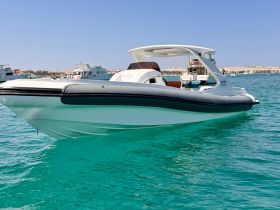 A sleek speedboat glides through clear turquoise waters, showcasing its elegant design and perfect for thrilling adventures on the sea.