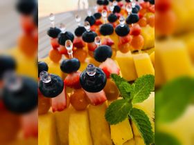 A vibrant display of fruit skewers featuring strawberries, blueberries, and pineapple, perfect for refreshing snacks on a boat trip.