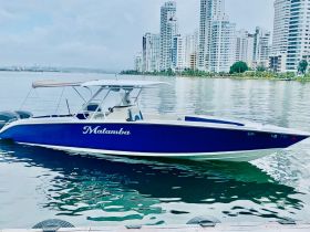 A sleek speedboat named 'Matamba' docked in calm waters, with a backdrop of modern skyscrapers, perfect for exploring coastal cities.