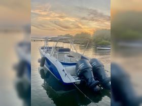 A sleek speedboat docked at sunset, reflecting the vibrant colors of the sky — perfect for evening cruises and water adventures.