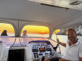 A joyful group enjoys a stunning sunset aboard a boat, capturing the essence of a perfect evening on the water.