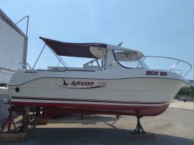 A side view of an Arvor 215 boat docked and ready for adventure, showcasing its sleek design and features.