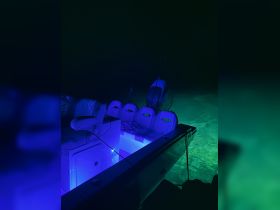 A beautifully lit interior of a boat showcasing comfortable seating and a helm, perfect for nighttime excursions on the water.